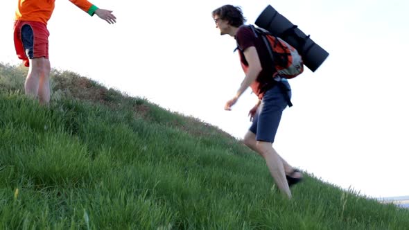 A tourist lends a helping hand while climbing the mountain. alt