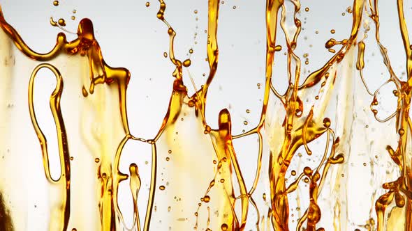 Super Slow Motion Shot of Splashing Golden Oil on White Background at 1000Fps alt
