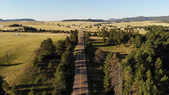 A reverse pan over a country road on a spring morning as a truck makes its way south alt