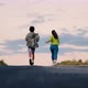 Slow motion two young people running with their friend at sunset - VideoHive Item for Sale