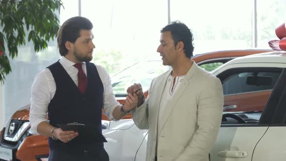 Mature Man Buying a New Car at the Dealership Salon alt