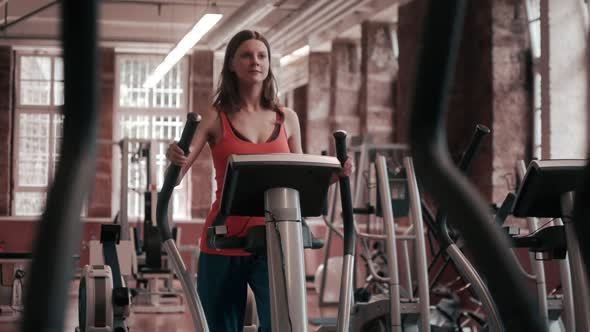 Young Woman Exercising On Elliptical Machine