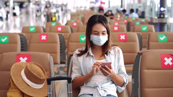 Young woman wearing a surgical mask and using mobile phone
