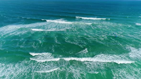 Top Down Aerial Shot of a Kiteboarder Having a Great Time Riding Waves