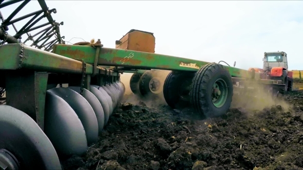 Trailer Of Tractor Plowing Soil In The Field
