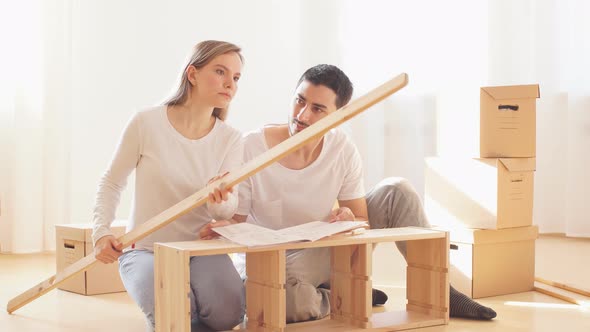 Couple Installing Furniture in New House with Instruction
