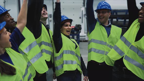 Team of multiracial engineers stacking hands together inside robotic factory - Tech industry concept