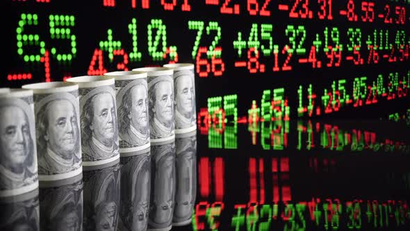 Hundred Dollar Bills On Background Moving Stock Market Tickers Financial Data.