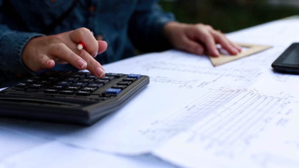 Architect make calculations on a calculator alt