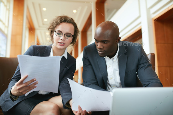 Two business partners sitting in cafe and discussing contract. - Stock Photo - Images