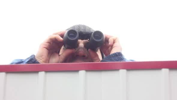 Man with Binoculars Jumping over the Fence