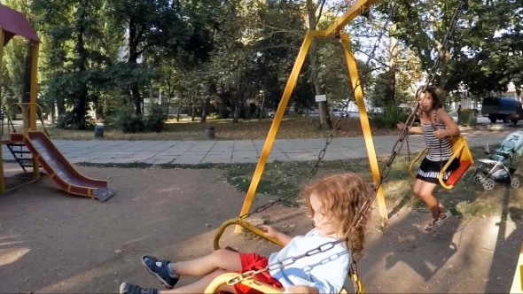Children Ride On The Swings