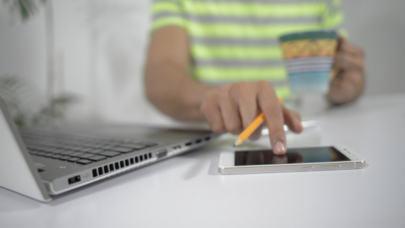 Designer Using Smartphone Holding Coffee in Hand alt