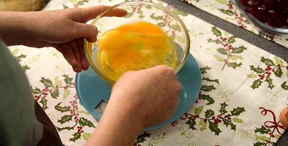 Woman Beats Together four Eggs in a Glass Bowl