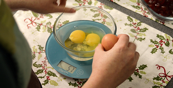 Woman Cracks Four Eggs into a Glass Bowl