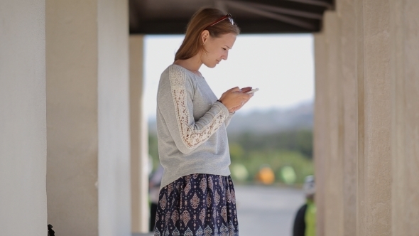 Young Pretty Girl Tourist At The Bus Stop Using alt
