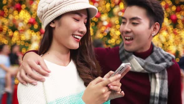 Merry Christmas and Happy New Year. Young  asian couple with Christmas lights alt