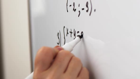 Elderly Teacher is Writing Equation on the Whiteboard