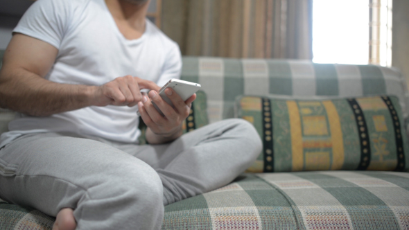 Casual Relax Man Using Smartphone on Sofa alt