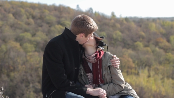 Couple In The Mountains Enjoying Life And Kissing