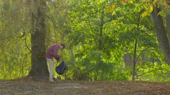 Man With Backpack Comes And Sits Under The Tree alt