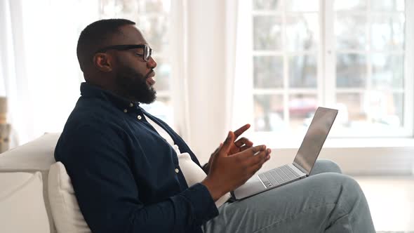 Pleased Young Bearded AfricanAmerican Guy in Casual Wear Waving Hand Into Webcam alt