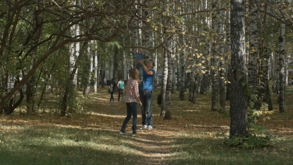 Happy Young Family Is Having Fun In The Autumn alt