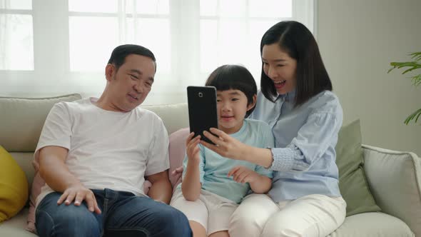 Asian family relaxing on the sofa in the living room, family relationship