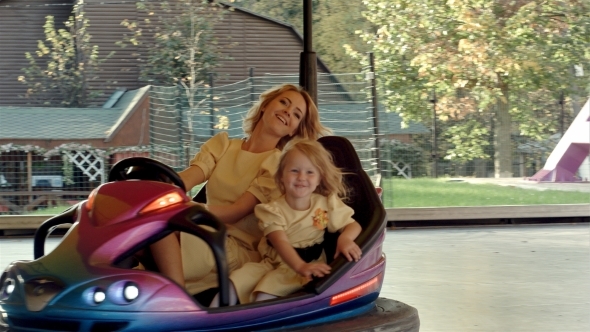 Young Mother With Her Daughter Drive On Bumper, Stock Footage | VideoHive