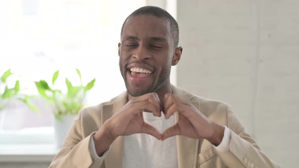 Portrait of African Man Showing Heart Shape By Hands alt