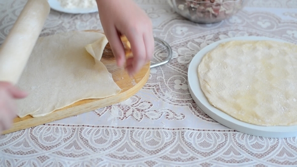 Children's Hands Unroll a  Dough For Pelmeni alt
