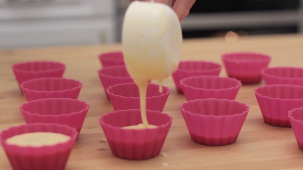 Cupcake Batter Being Poured Into Cupcake Form.