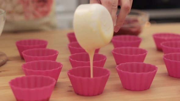 Cupcake Batter Being Poured Into Cupcake Form.