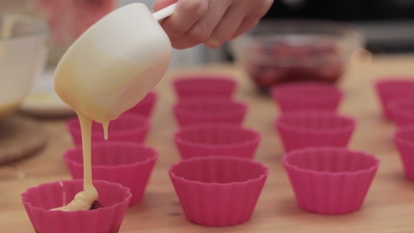 Cupcake Batter Being Poured Into Cupcake Form.