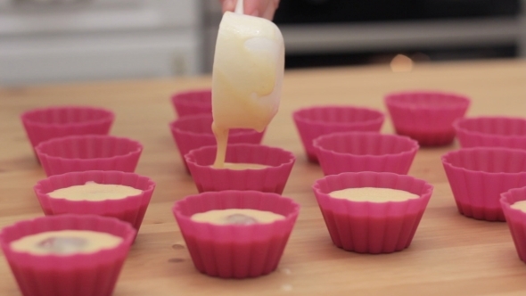 Cupcake Batter Being Poured Into Cupcake Form.