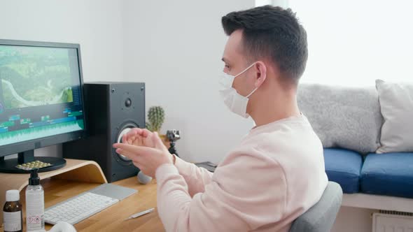Ill Sick Man in Face Mask Uses Hand Sanitizer Before Work at PC in Home Office