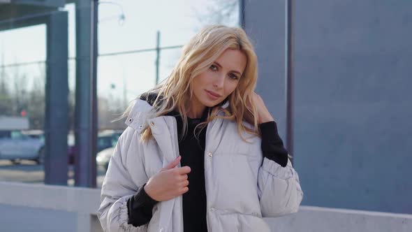 Young Charming Lady in Coat on Street Near Building  alt