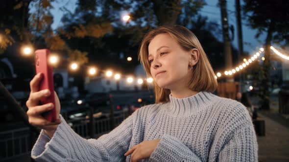 Tourist student girl walking in the street of city making video call, talking with friends. alt