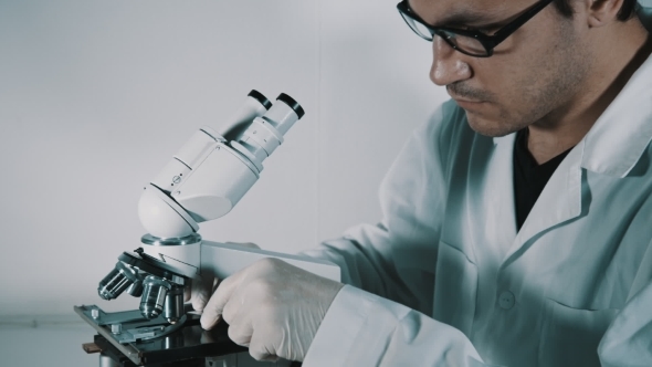 Young Doctor  Looking Through The Microscope alt