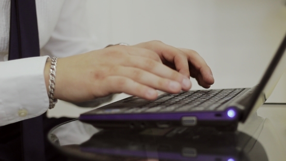 The Guy In The White Shirt Is Typing On a Laptop