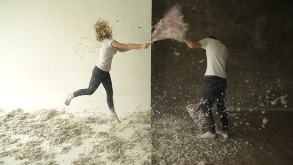 Young Couple Fighting Pillows In The Studio