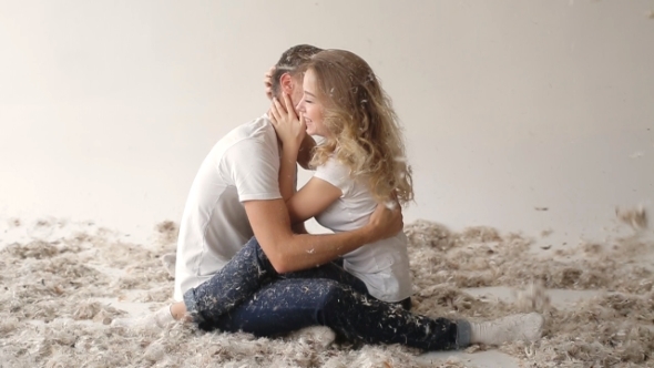 Young Couple Fighting Pillows In The Photostudio