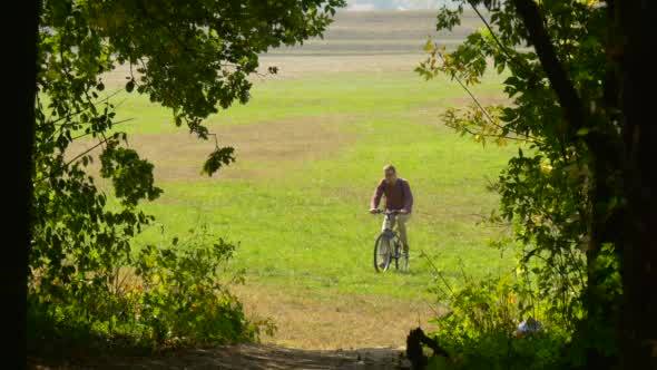 Man Rides On The Bicycle He Rises Up On The Hill alt