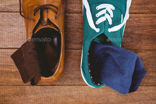 View of two different shoes on wood plank
