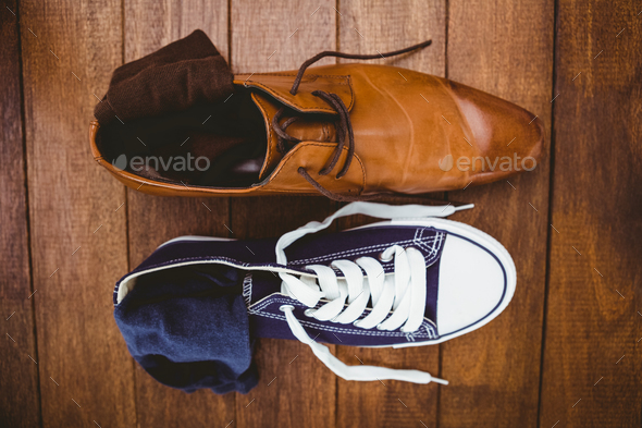 View of two different shoes on wood plank