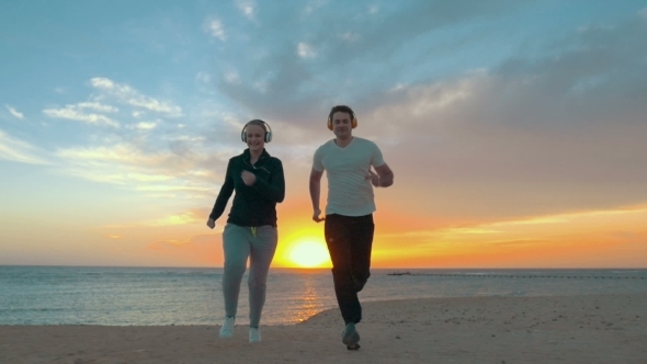 Young Couple Jogging On The Beach alt