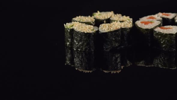 Set of Maki Sushi on a Black Surface Closeup alt