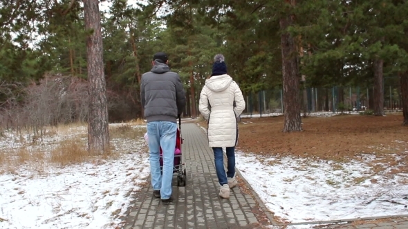 Young Family With a Child Walks In The Street