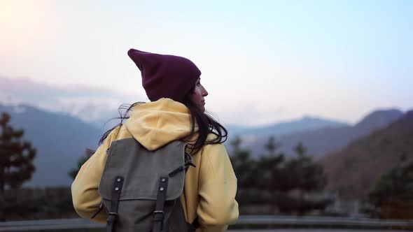 Active Travel Backpacker Woman Walking at Sunset Landscape Admiring Snow Mountain Peak Back View alt