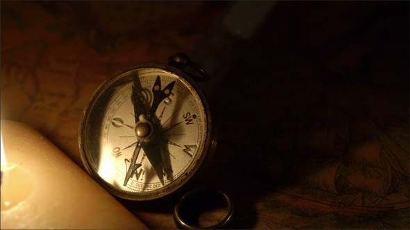 A Lighted Candle Beside a Compass
